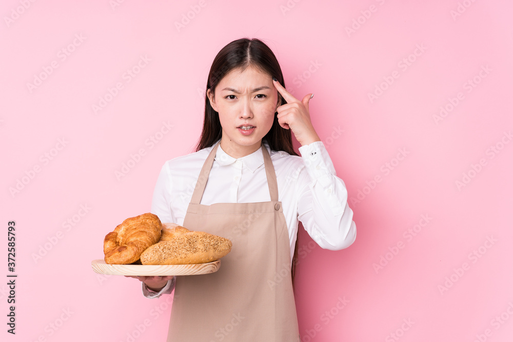 Young chinese baker woman isolated showing a disappointment gesture with forefinger. Young chinese baker woman isolated showing a disappointment gesture with forefinger.