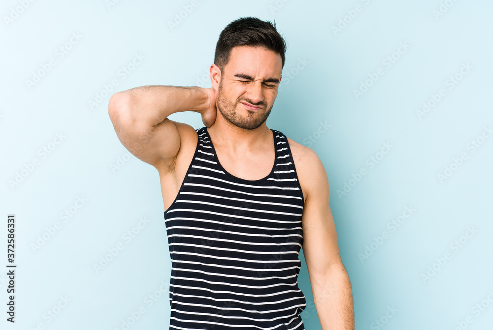 Young caucasian man isolated on blue background having a neck pain due to stress, massaging and touching it with hand. Young caucasian man isolated on blue background having a neck pain due to stress, massaging and touching it with hand.