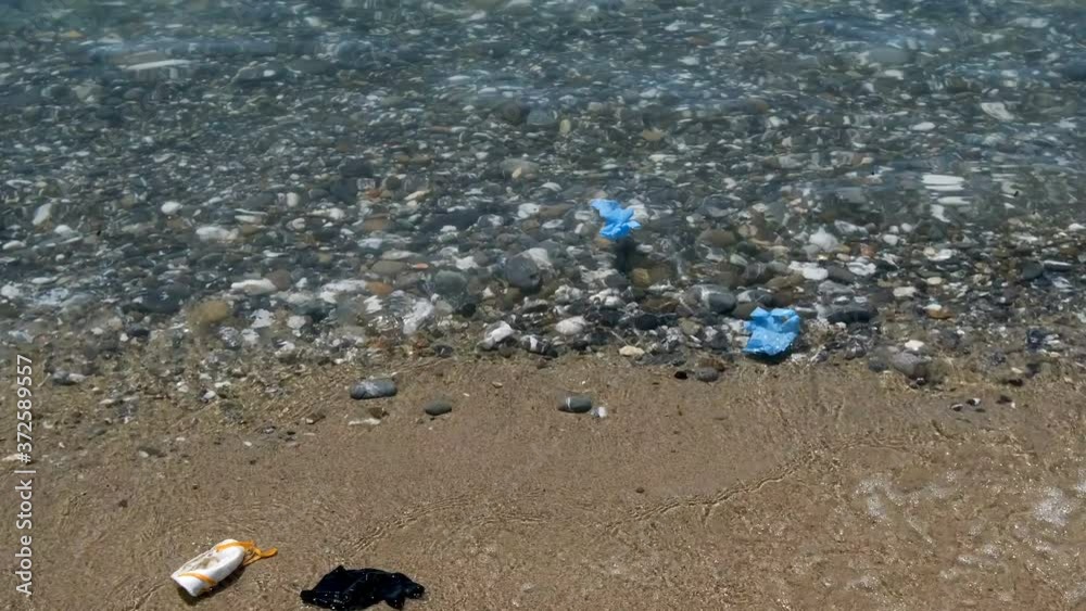 Floating Virus ffp2 protective mask and plastic gloves garbage on sea water,coronavirus covid pollution Floating Virus ffp2 protective mask and plastic gloves garbage on sea water,coronavirus covid pollution