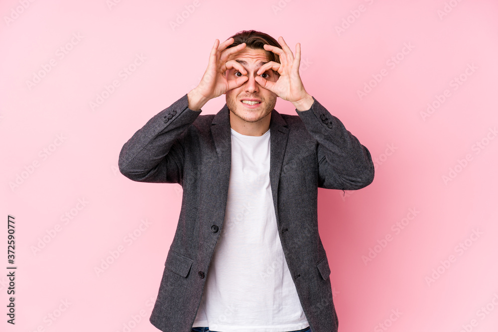 Young caucasian business man posing isolated showing okay sign over eyes Young caucasian business man posing isolated showing okay sign over eyes