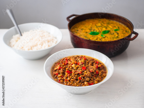 Vegetarian Vegan Indian Buffet of Chick Pea and Spinach Curry, White Rice and Lentil Dhal Stew in Various Pots and Bowls on a White Background