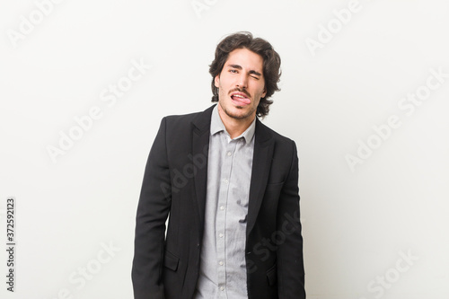 Young business man against a white background funny and friendly sticking out tongue.