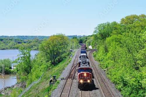 An image of an oncoming CN freight train on the Canadian Railway going through Ontario, Canada carrying various containers, tanks and cargoes.