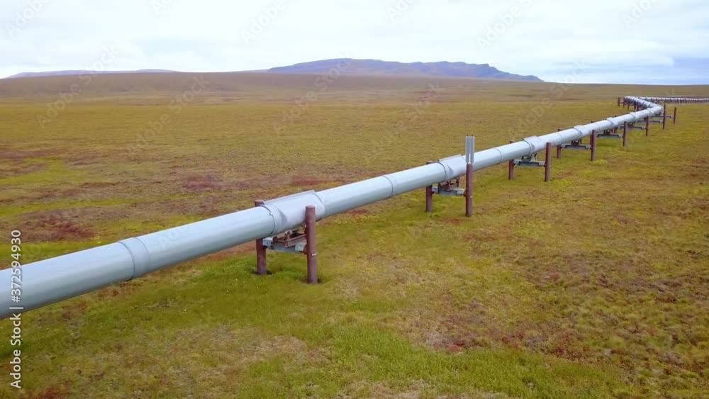 Aerial view following the crude oil pipeline, at the Dalton Highway, cloudy, fall day, in Alaska, USA - reverse, drone shot Aerial view following the crude oil pipeline, at the Dalton Highway, cloudy, fall day, in Alaska, USA - reverse, drone shot