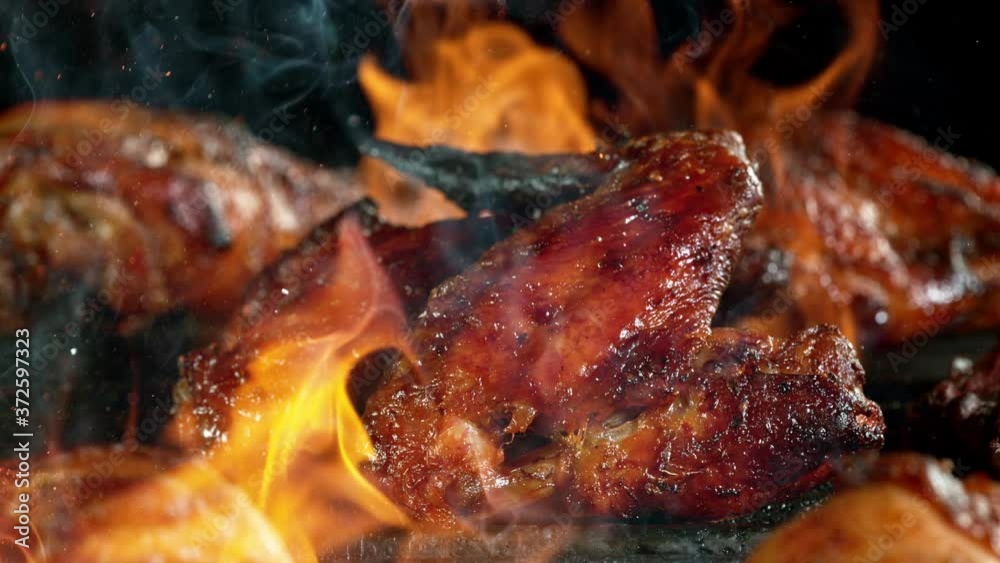 Close-up of falling raw tasty chicken legs on iron cast grate, super slow motion, filmed on high speed cinematic camera at 1000 fps. Close-up of falling raw tasty chicken legs on iron cast grate, super slow motion, filmed on high speed cinematic camera at 1000 fps.