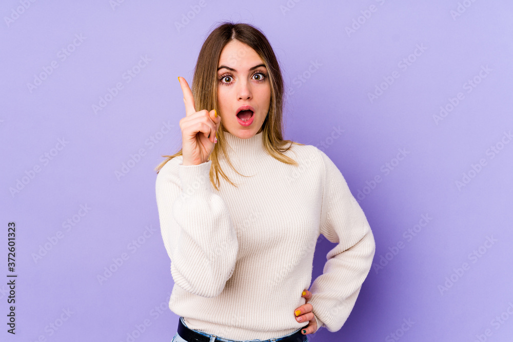 Fototapeta premium Young caucasian woman isolated on purple background having an idea, inspiration concept.