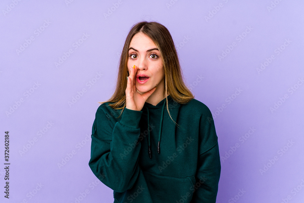 Young caucasian woman isolated on purple background is saying a secret hot braking news and looking aside Young caucasian woman isolated on purple background is saying a secret hot braking news and looking aside
