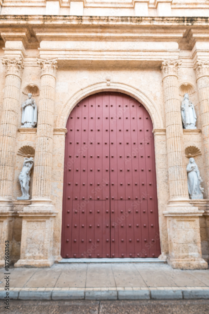 Cartagena, Colombia. August 20, 2020: Façade of a colonial church in Cartagena with a wooden and coral stone door