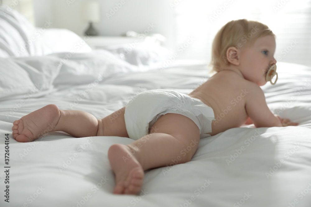 Cute little baby in diaper in bedroom, focus on legs Cute little baby in diaper in bedroom, focus on legs