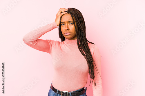 Young african american woman isolated on a pink background tired and very sleepy keeping hand on head.