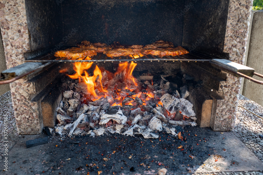 some marinated steaks on a charcoal grill on a barbecue some marinated steaks on a charcoal grill on a barbecue
