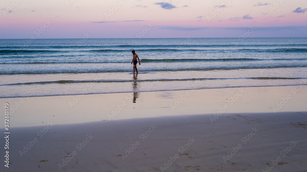 Landscape shot of young person going for a swim in ocean