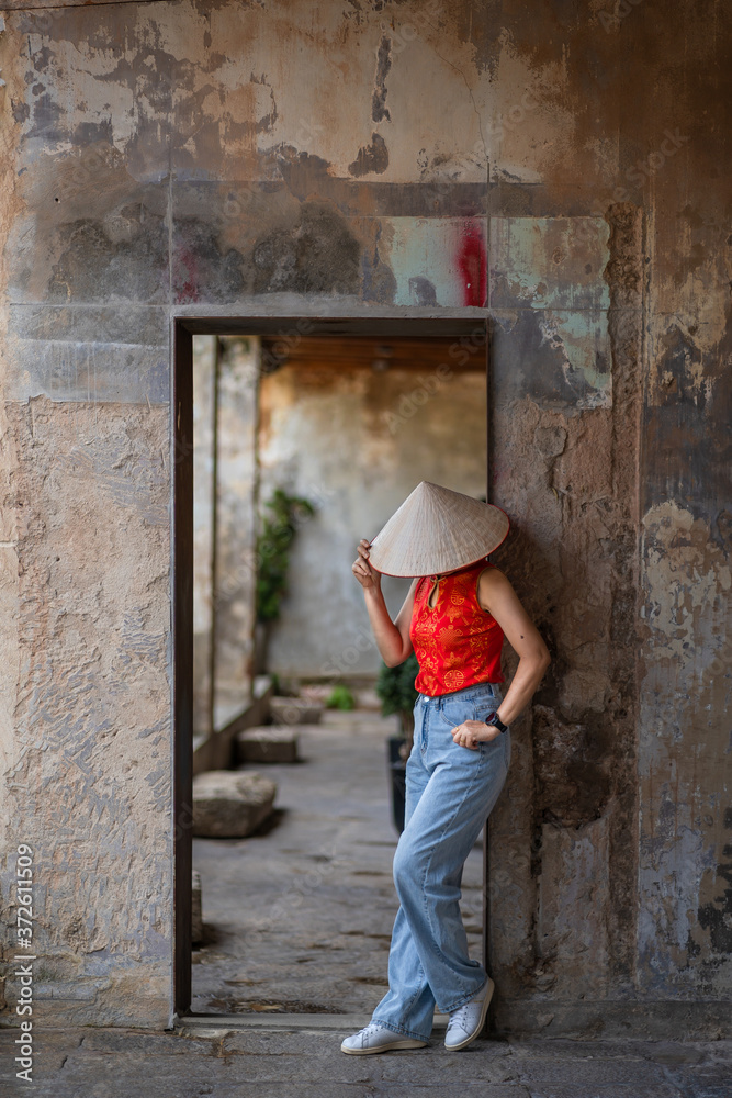 Vietnamese girls wearing red shirt with straw hat made of palm leaves are visiting antique place historical architecture in Thailand destination ancient building