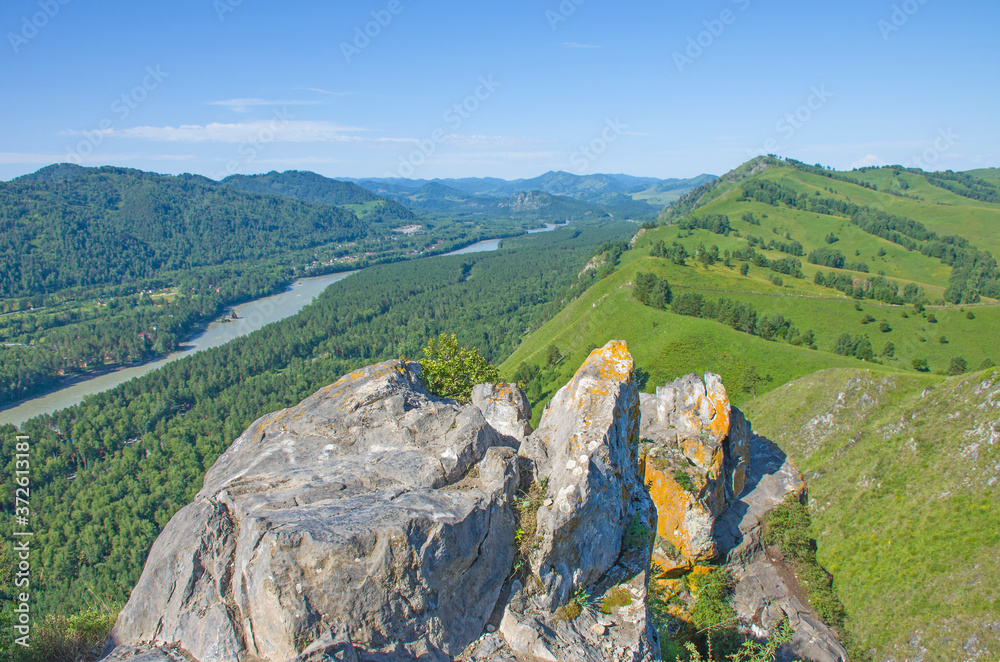 Stone rock against the backdrop of mountains and river Altai beautiful landscape in summer