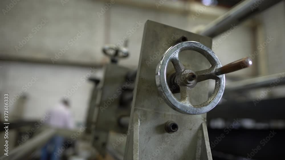A slow dolly in of a forged steel valve wheel with a silhouette of a working man. A slow dolly in of a forged steel valve wheel with a silhouette of a working man.