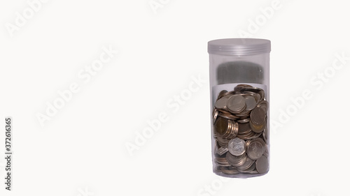 Lots of coins in a cylinder isolated from a white background.