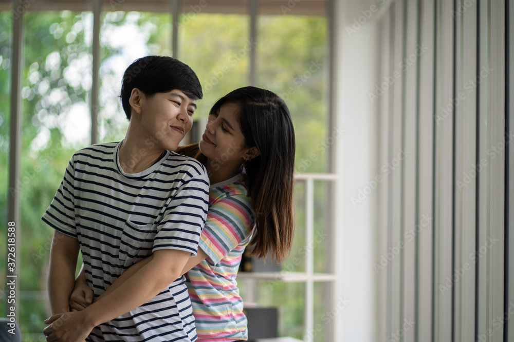 Happy asian lesbian couple hug each other with love on at living room at home,LGBTQ lifestyle concept