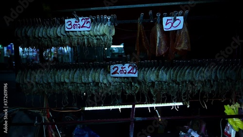 Chargrilled Dried Squid, Pla Muek Yang, Street Food in Thailand; commonly found on the streets of Bangkok and it is quite a popular healthy food for people to grab and eat on the go. photo