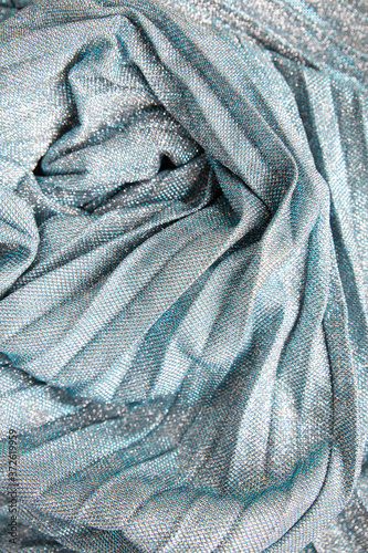 Glamor shimmering background.Silver sparkling ,Festive abstract shiny background with flashing lights. The fabric glitters,bright color.fabric texturep. Metallic glitter blue, grey cloth texture photo