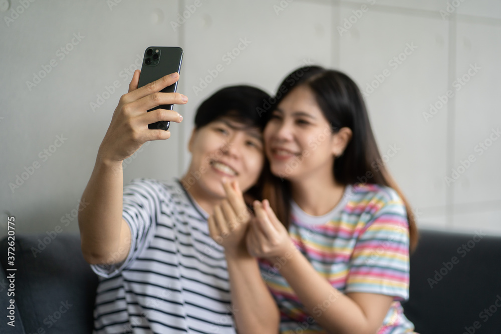 Happy girlfriends looking at a smartphone and having fun - 