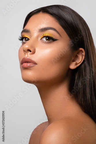 Closeup portrait of a beautiful girl with a bright sunny makeup. Beauty style shot. Clean skin and hair. Close up. photo