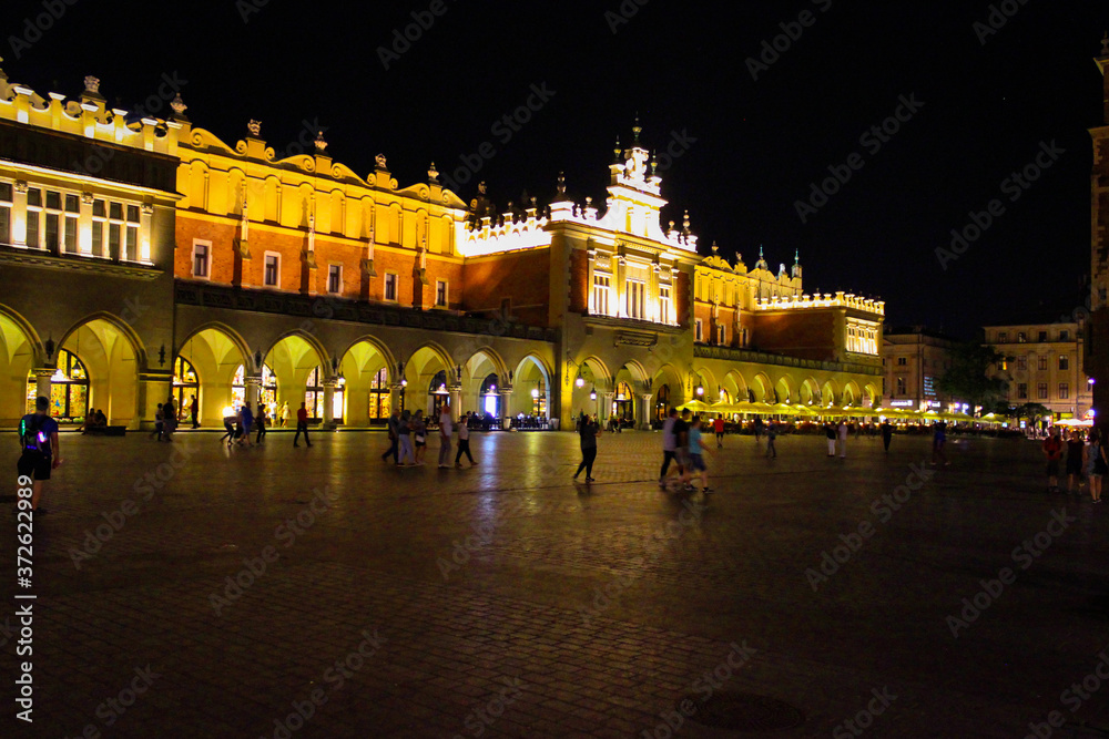 Obraz premium Krakow, Poland - July 20, 2017: In Summer Evening People Walk On The Main Square In Royal City Krakow In Poland.