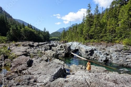 A woman exploring Wally Creek, on the way to Tofino.  The water is magical for swimming, the flowing creek water glistens with a clear, aquamarine hue that is spellbinding to behold.