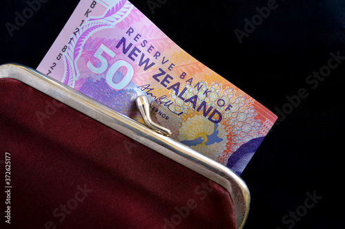 New Zealand dollars in a red purse.