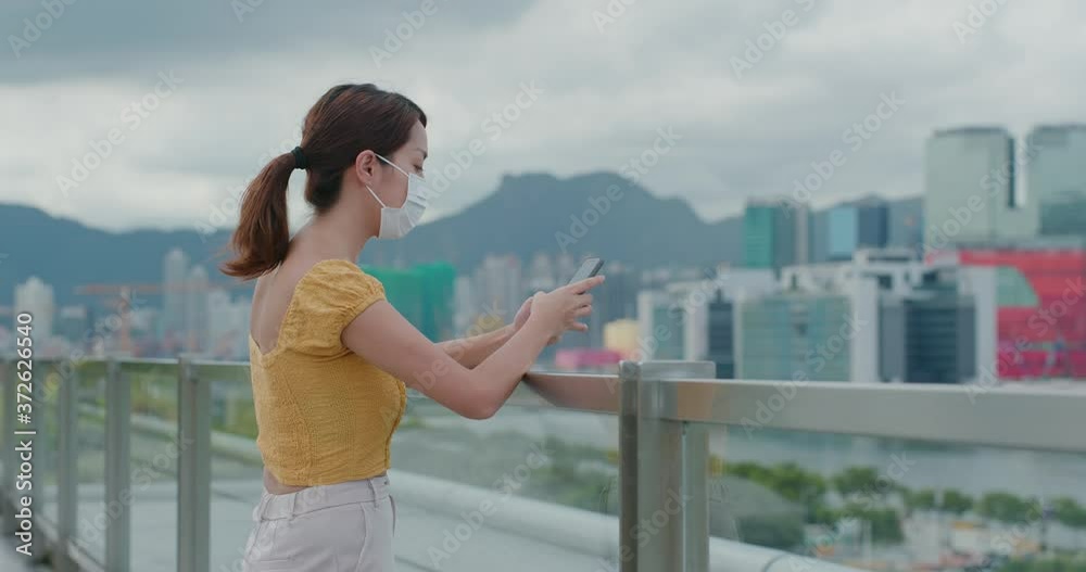 Woman wear face mask and use of mobile phone in city Woman wear face mask and use of mobile phone in city