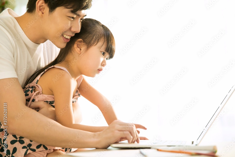 father teaching daughter to use notebook computer father teaching daughter to use notebook computer