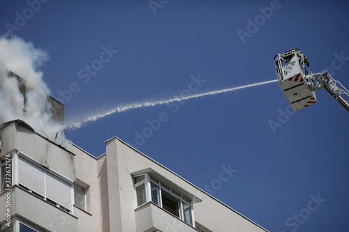 Firefighters try to extinguish a fire that spread across an apartment in a block of flats. photo