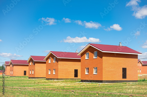 new cottage settlement. a row of newly built two-story houses. concept of construction of low-rise buildings