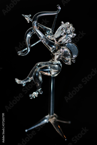 Transparent glass cupid isolated on black background
