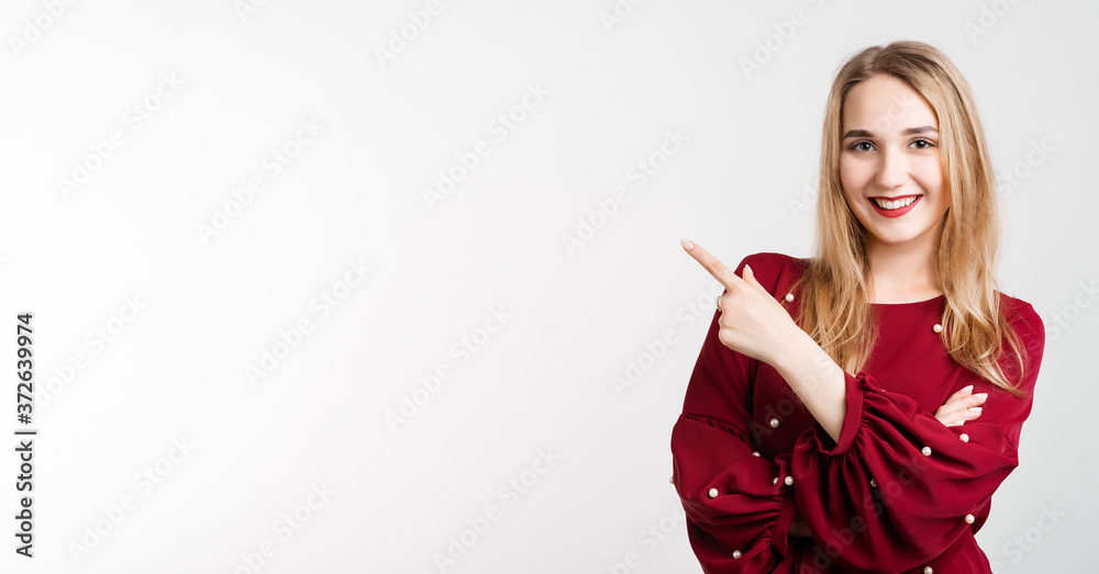 You better see it. Intrigued European girl with long blonde hair, points away with one finger, shows blank space for your promotion. People, advertisement concept You better see it. Intrigued European girl with long blonde hair, points away with one finger, shows blank space for your promotion. People, advertisement concept