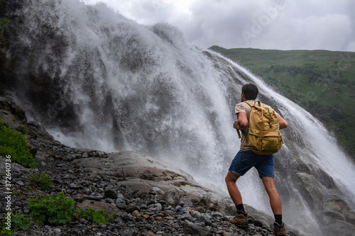 Waterfall Landscape and male Traveler enjoying waterfall view.