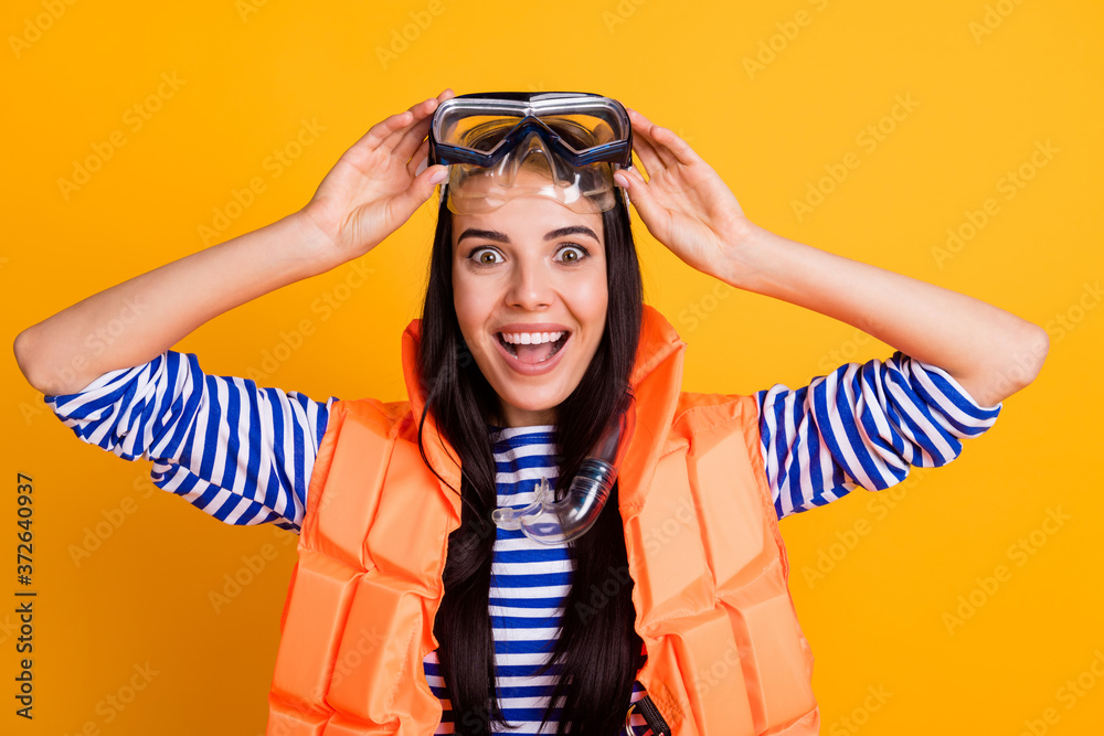 Close up photo of surprised positive girl tourist touch goggles look tourism lifeguard rescue people impressed wear tube mask vest white blue striped shirt isolated yellow color background