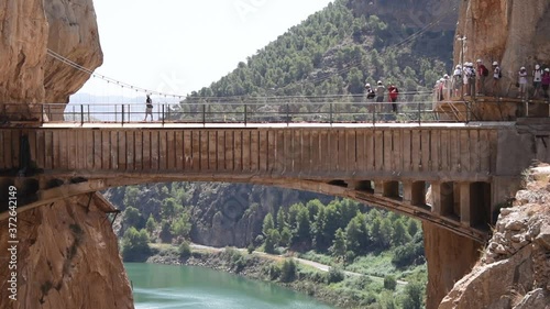 Adventurous climbers crossing the Caminito Del Rey suspension bridge