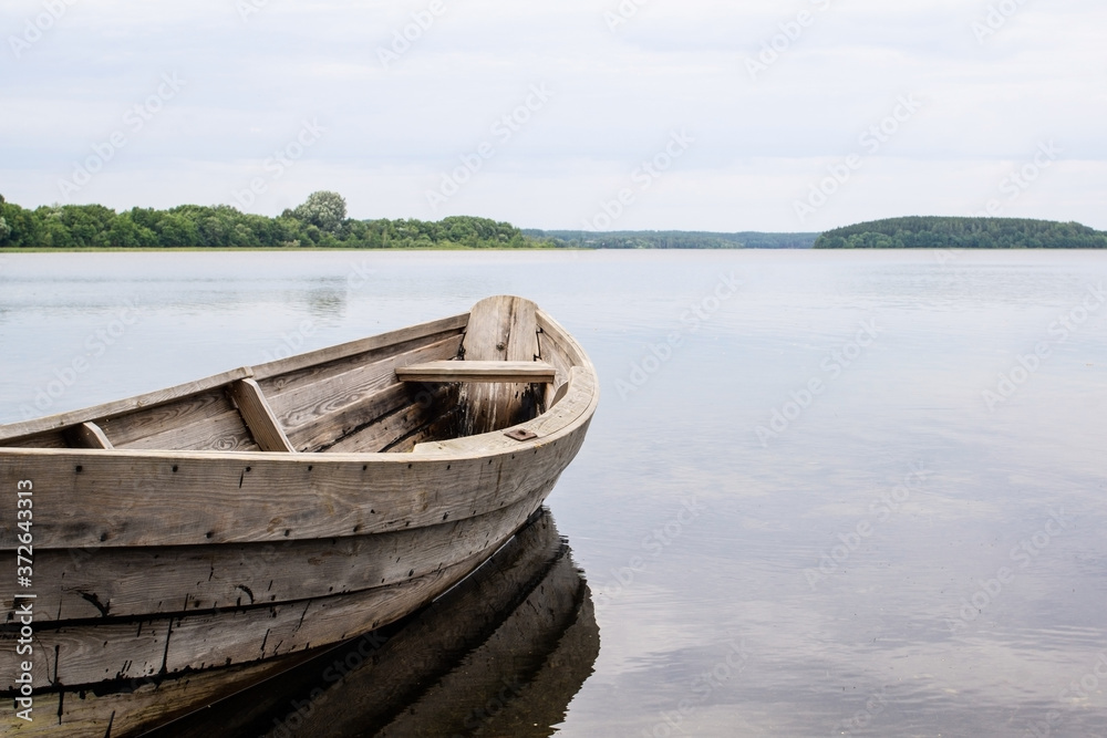 Boat on the lake. Wooden boat on a calm summer lake or river in summer. Zen nature background.