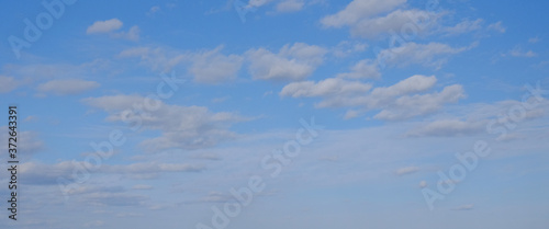 Blue spring sky with white clouds. Beautiful background.