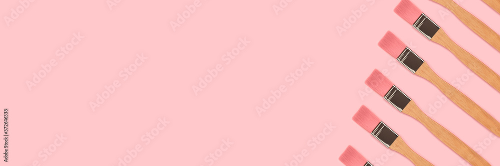 Paint brushes pattern on a pink pastel background. Creative layout. Paint brushes pattern on a pink pastel background. Creative layout.
