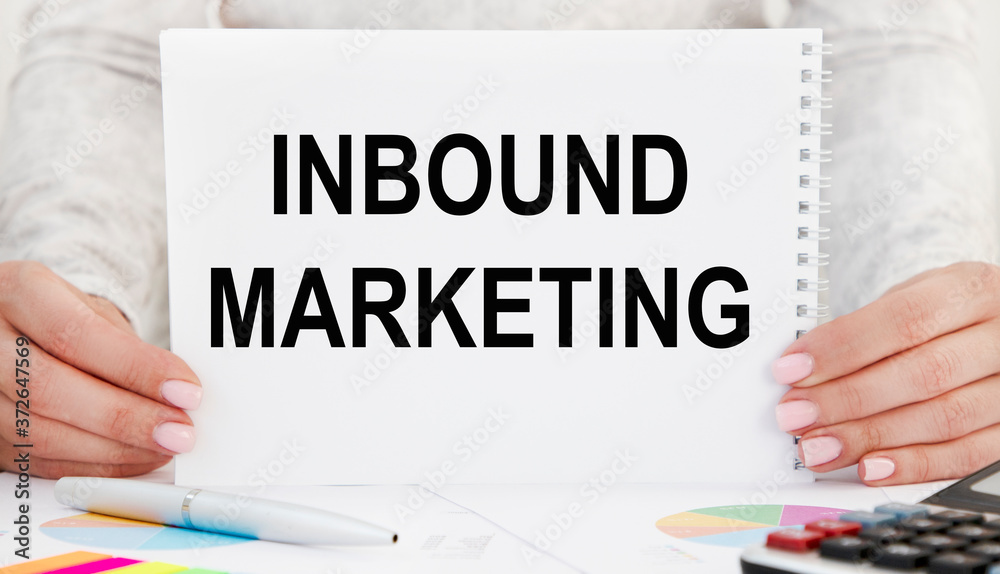 The girl holds a notebook with the inscription: INBOUND MARKETING. The girl holds a notebook with the inscription: INBOUND MARKETING.