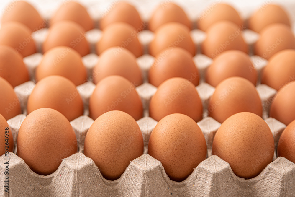 Many fresh raw brown chicken eggs in carton box. Many fresh raw brown chicken eggs in carton box.