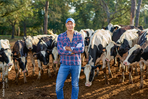 Farmer is working on farm with dairy cows. © JENOCHE