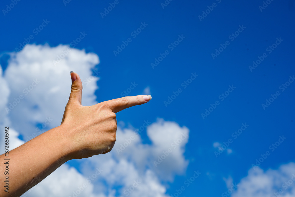 Woman pointing his hand and cloud sky background Woman pointing his hand and cloud sky background