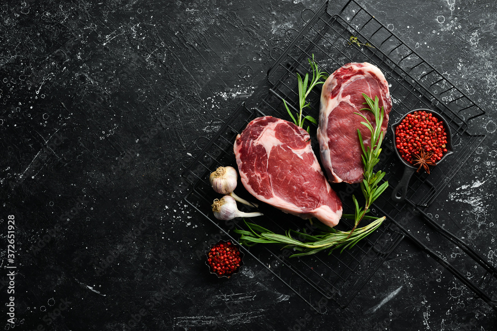 Raw meat, beef steak on dark background. Top view. Free space for your text.