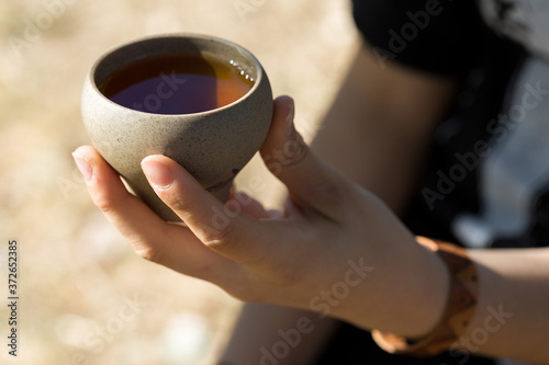 Ceramic bowls made of clay on a wooden background. .The girl is drinking Chinese tea.