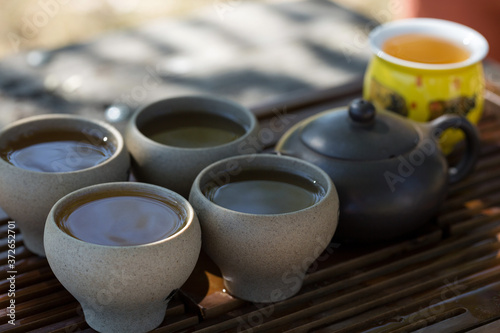 Chinese tea ceremony. Ceramic teapot made of clay and bowls on a wooden background.