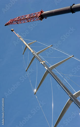 Placing the mast on a super sailing yacht. Cranes. Harbor of Harlingen Netherlands. Ship building industry. © A
