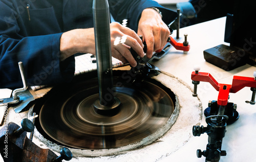 Amsterdam, Netherlands - July 2019: A skilled worker are shaping diamond they at the factory in Amsterdam, Netherlands. photo