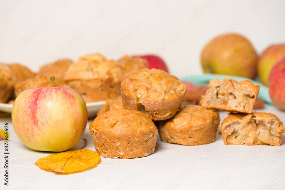 homemade Apple cupcakes and muffins, light background, yellow leaves. the concept of fall baking and fall harvest. cupcake is broken into pieces, filling with Apple homemade Apple cupcakes and muffins, light background, yellow leaves. the concept of fall baking and fall harvest. cupcake is broken into pieces, filling with Apple